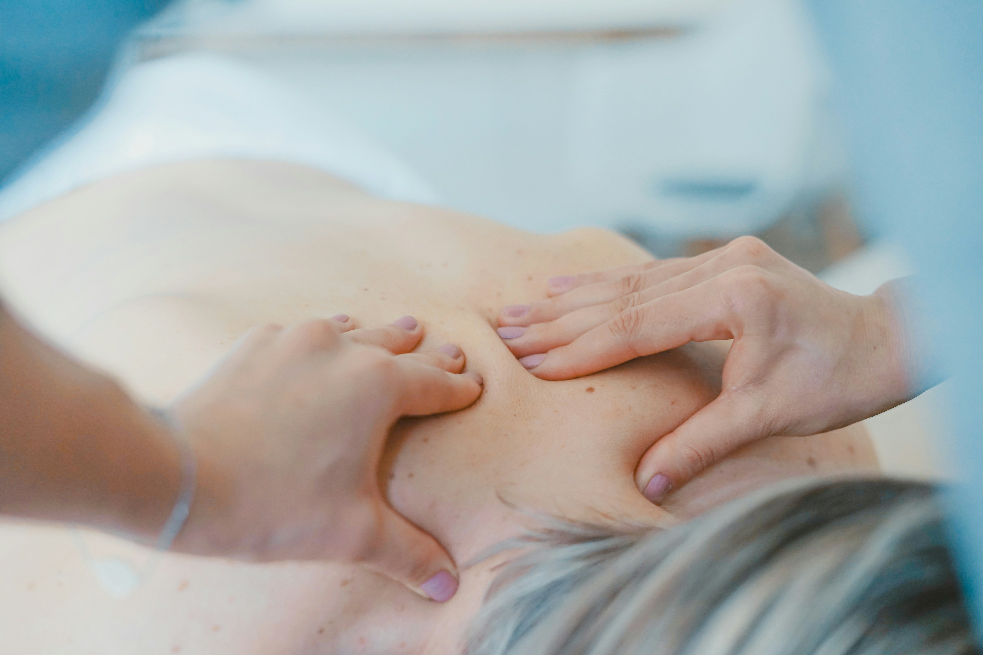 A massage therapist's hands at work, soft natural light